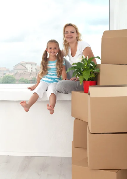 Mujer feliz y niña en un nuevo hogar - tema en movimiento —  Fotos de Stock