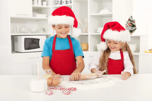 Feliz Natal crianças esticando a massa de biscoito — Fotografia de Stock