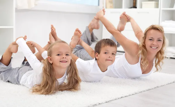 Famiglia che fa esercizi di stretching a casa — Foto Stock
