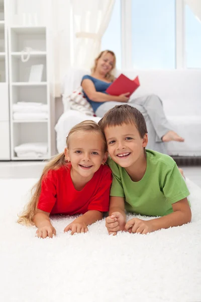 Děti, kterým se na podlaze v obývacím pokoji — Stock fotografie