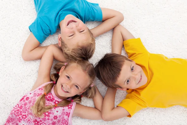 Tre bambini sdraiati sul pavimento in cerchio — Foto Stock
