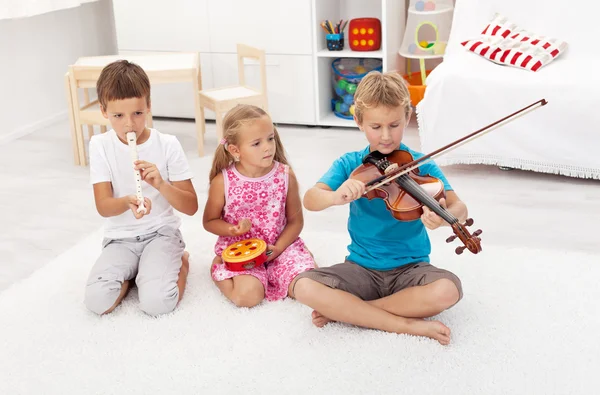 Gyerekek próbál játszani a különböző hangszerek — Stock Fotó