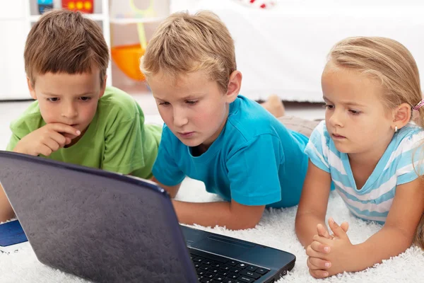 Focused kids looking at laptop computer — Stok fotoğraf