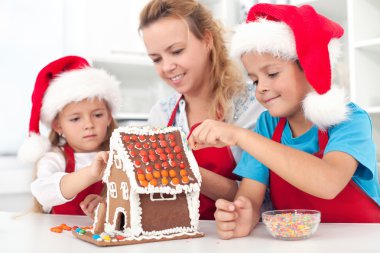 Preparing a gingerbread cookie house clipart