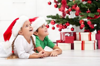 Siblings with lots of presents at christmas time clipart