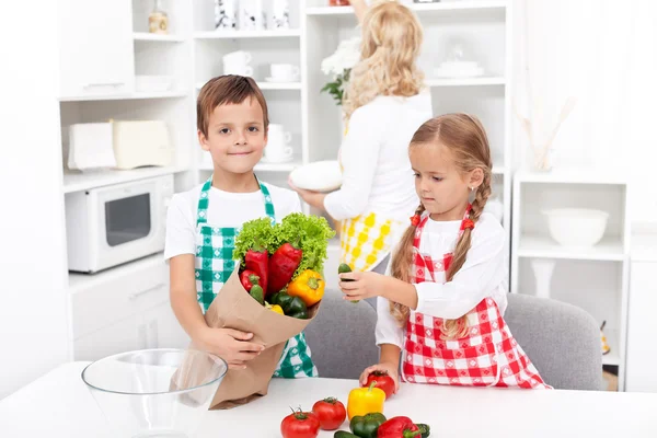 Niños desempacando comestibles en la cocina —  Fotos de Stock