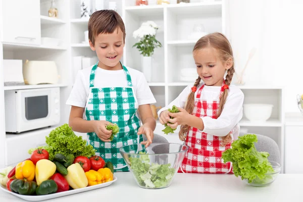 Dzieci w kuchni przygotowując sałatka — Zdjęcie stockowe