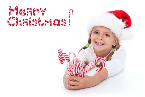 Little girl with lots of candy canes — Stock Photo, Image