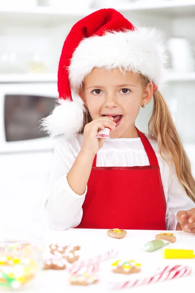 Маленькая девочка украшает рождественское печенье — стоковое фото