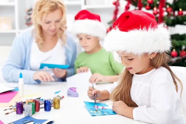 Family making seasonal greeting cards together — Stock Photo, Image