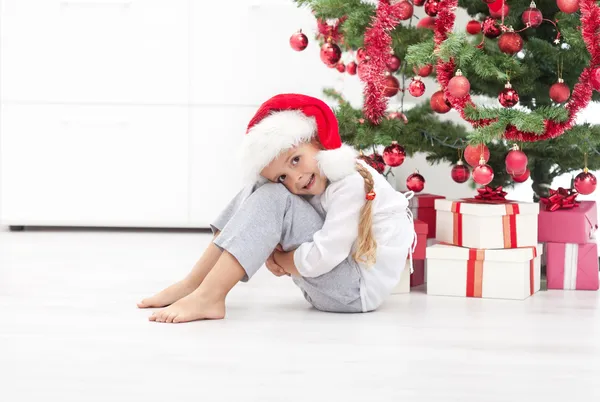 Ευτυχισμένη κοριτσάκι κάτω από το χριστουγεννιάτικο δέντρο — Φωτογραφία Αρχείου