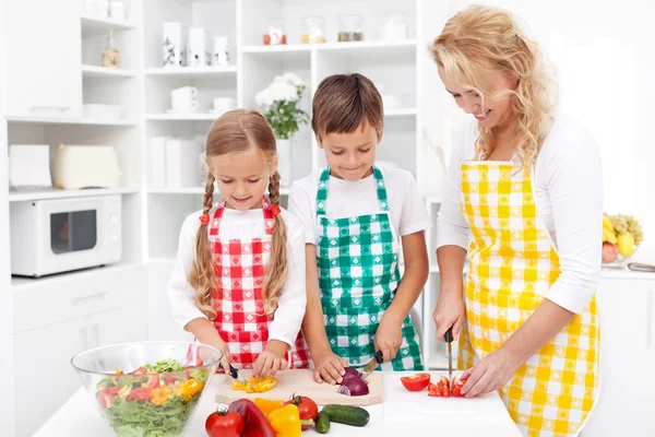 Family preparing fresh salad — Stock Photo, Image