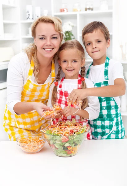 Voorbereiding van verse salade en gelukkige familie — Stockfoto