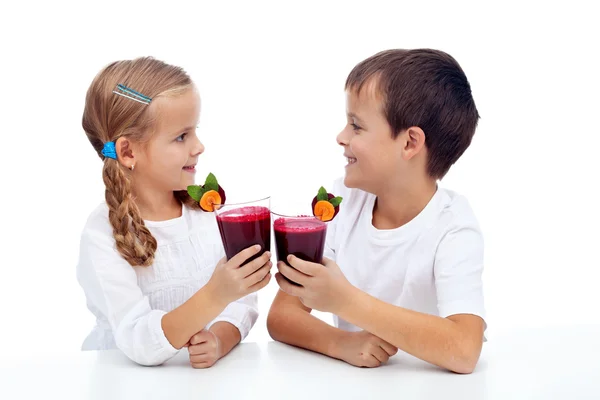 Kids clinking with fresh juice — Stock Photo, Image