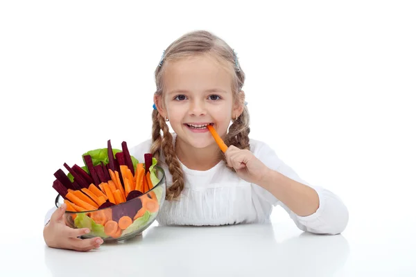 Маленькая девочка жует морковную палочку — стоковое фото