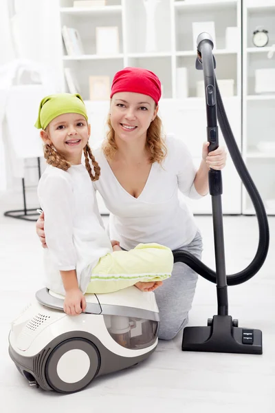 Gün - kadın ve küçük kızı elektrikli süpürge ile temizlik — Stok fotoğraf