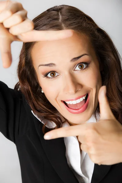 Γυναίκα των επιχειρήσεων πλαισιώνουν το πρόσωπό της με τα χέρια, πέρα από το γκρι — Φωτογραφία Αρχείου
