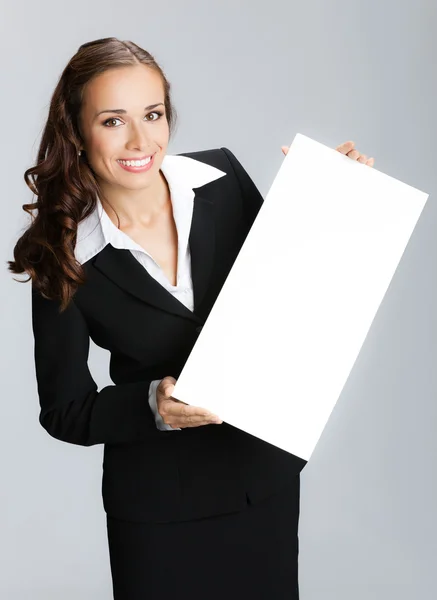 Бізнес-леді, що показує вивіску, над сірим — стокове фото