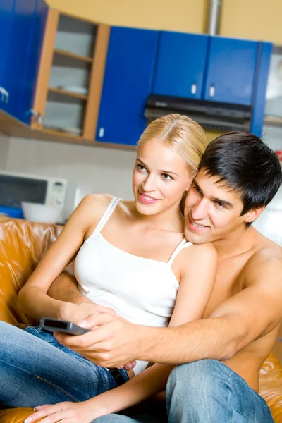 TV togeher evde izlerken mutlu genç bir çift — Stok fotoğraf