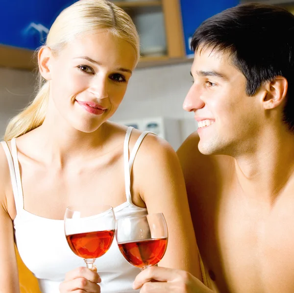 Молодая пара празднует дома с красным вином — стоковое фото