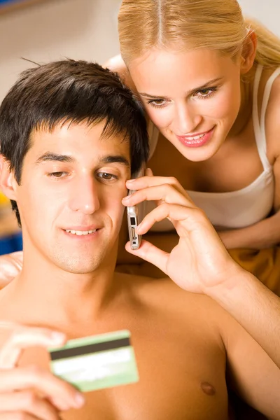Casal jovem no celular de compras com cartão de crédito — Fotografia de Stock