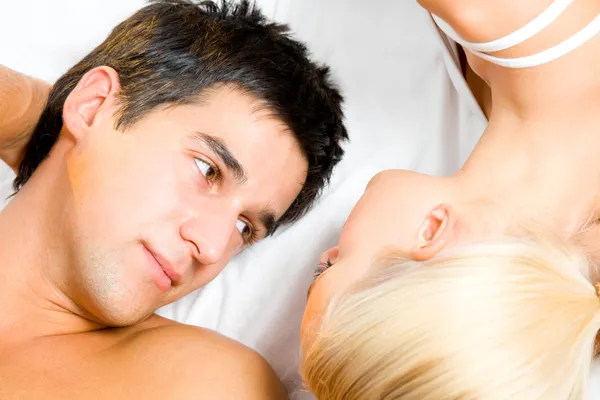Молодая привлекательная счастливая влюбленная пара в спальне Стоковое Изображение