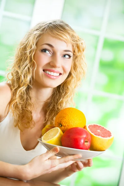 Mulher com prato de frutas, dentro de casa — Fotografia de Stock