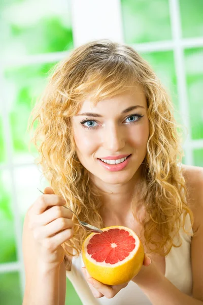 Ung kvinna med grapefrukt hemma — Stockfoto