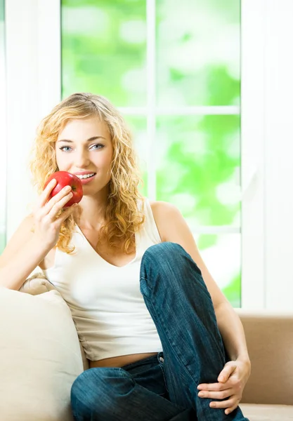 Donna con mela rossa, a casa — Foto Stock