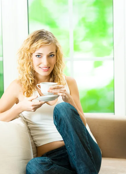 Jovem sorrindo mulher bebendo café, em casa — Fotografia de Stock