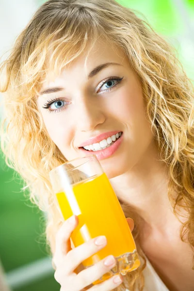 Mujer joven con jugo de naranja en casa —  Fotos de Stock