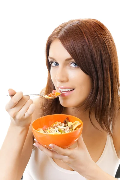 Portret młodej kobiety uśmiechający się jedzenie muślinu, na białym tle — Zdjęcie stockowe