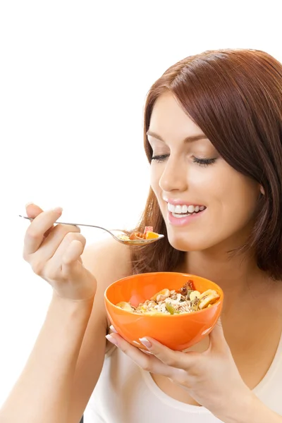 Portret młodej kobiety uśmiechający się jedzenie muślinu, na białym tle — Zdjęcie stockowe