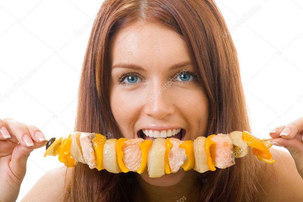 Portrait of young happy woman eating shish kebab, isolated