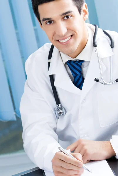 Szczęśliwy uśmiechający się lekarz pracuje w urzędzie — Zdjęcie stockowe