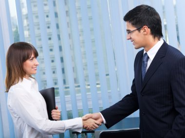 Two happy businesspeople, or businessman and client, handshaking clipart