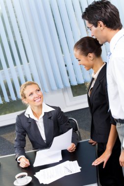 Three businesspeople or businesswoman and clents at office clipart