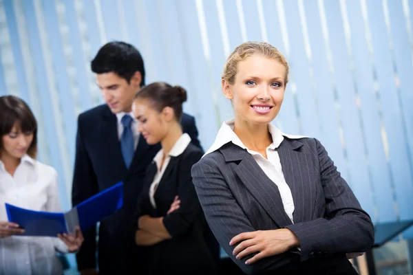 Портрет счастливой улыбающейся деловой женщины и коллег в офисе — стоковое фото