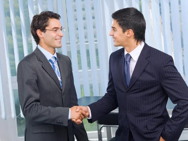 Двоє бізнесменів вітають рукостискання в офісі — стокове фото