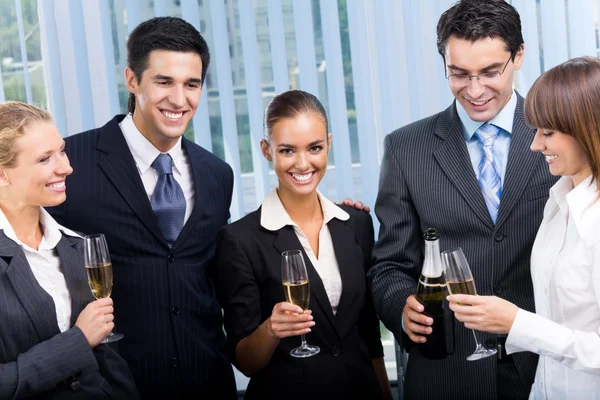 Felices jóvenes empresarios sonrientes celebrando con champán en —  Fotos de Stock