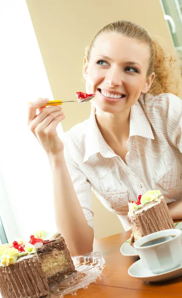 Fiatal boldog mosolygó gyönyörű fiatal nő evés torta otthon — Stock Fotó