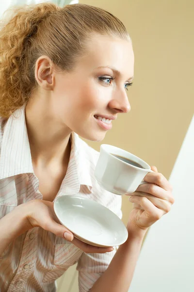 Joven mujer sonriente bebiendo café, en casa —  Fotos de Stock