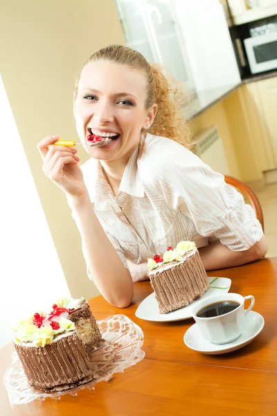 Jonge gelukkig lachend mooie jonge vrouw eten torte — Stockfoto