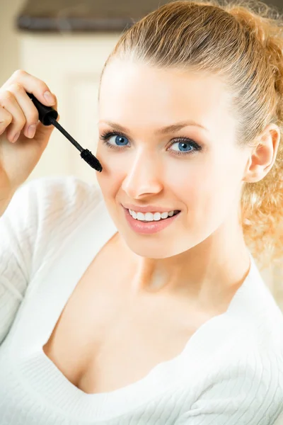 Young woman applying mascara with lash brush at home — Stock Photo, Image