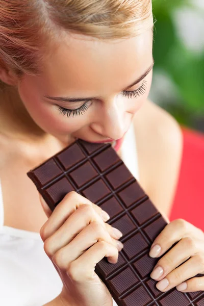 Όμορφη κοπέλα που τρώει σοκολάτα στο σπίτι — Φωτογραφία Αρχείου