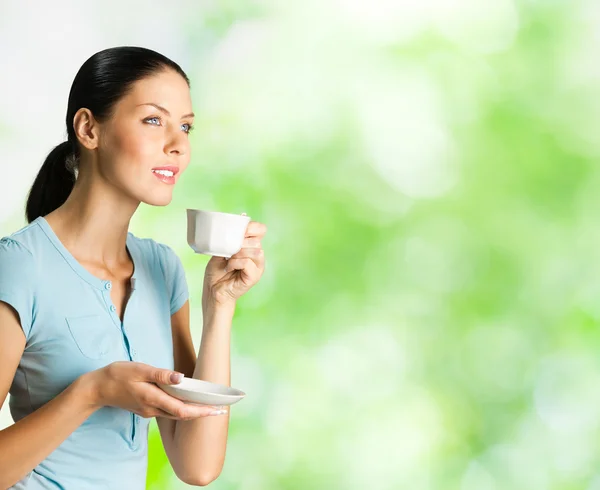 Jovem mulher feliz bebendo café, ao ar livre — Fotografia de Stock