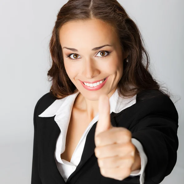 Businesswoman with thumbs up, over grey — Stock Photo, Image