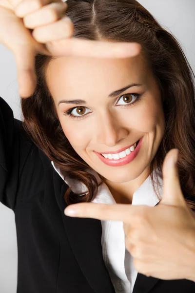 Empresária enquadrando seu rosto com as mãos, sobre cinza — Fotografia de Stock