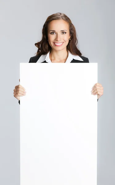Деловая женщина показывает вывеску, над серым — стоковое фото