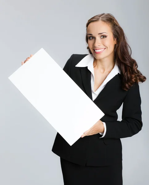 Бізнес-леді, що показує вивіску, над сірим — стокове фото